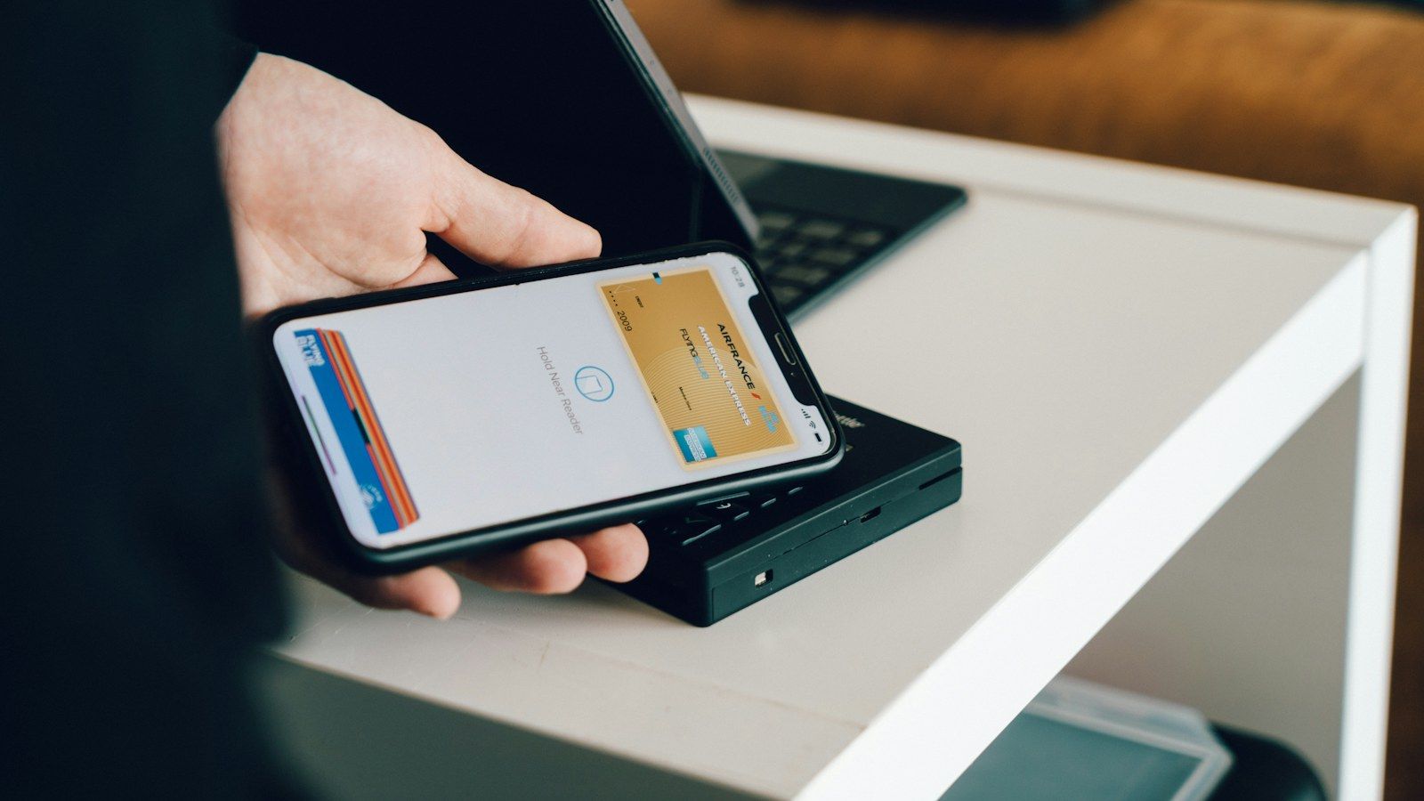 A shopper pays by phone, with several payment cards stacked in the digital wallet